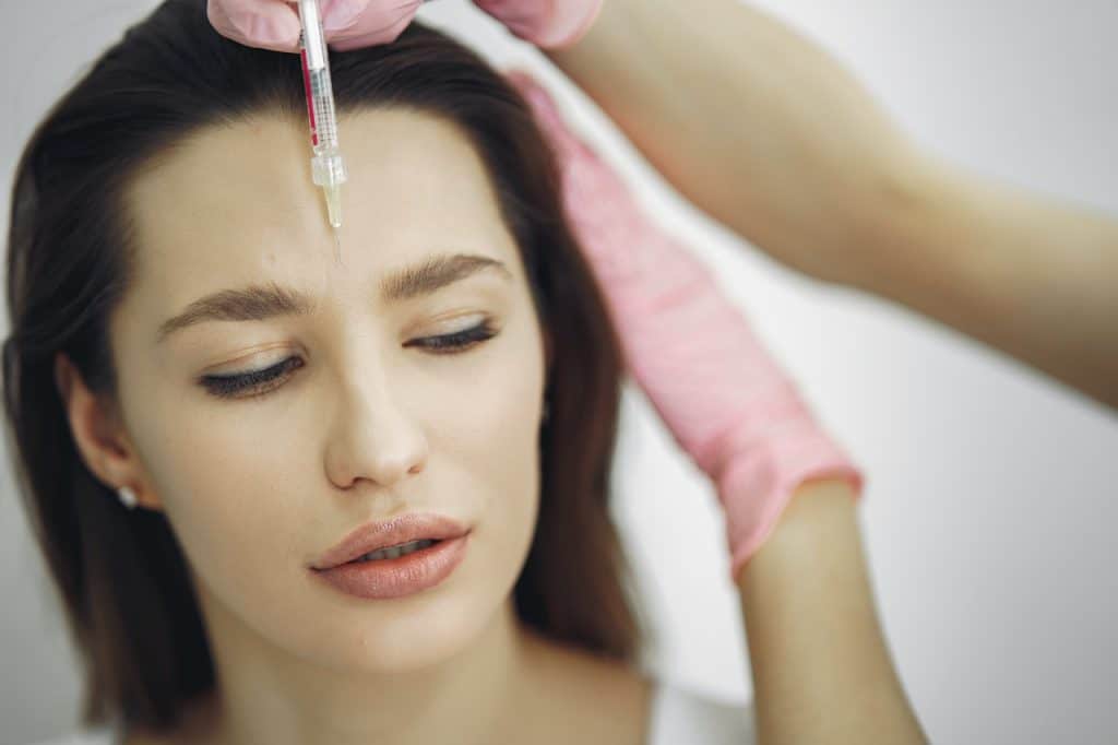 jeune femme qui fait des injections dans un cabinet de médecine esthétique